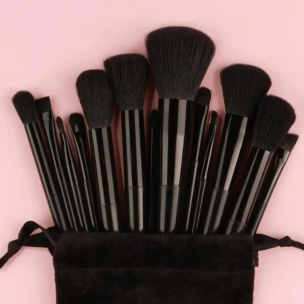 Set of makeup brushes in a black pouch on a pink background. Soft fluffy makeup brush set with wool fiber bristles and plastic handles. Complete set for powder, foundation, eyeshadow, and beauty blending.