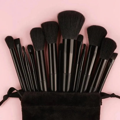 Set of makeup brushes in a black pouch on a pink background. Soft fluffy makeup brush set with wool fiber bristles and plastic handles. Complete set for powder, foundation, eyeshadow, and beauty blending.