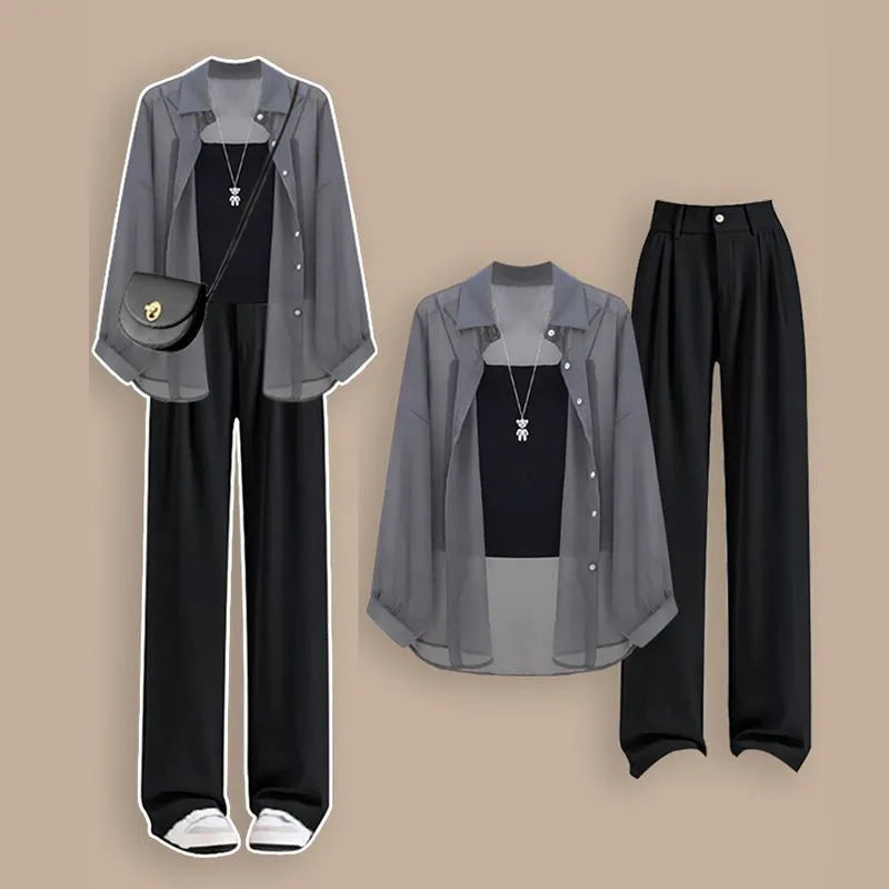 Fashion outfit with black pants, sheer gray shirt, and black top on a beige background. Women’s 3-piece French style set: chiffon cardigan, sling shirt, high-waist wide leg pants. Chic, lightweight and sun-protective fashion for spring/summer.