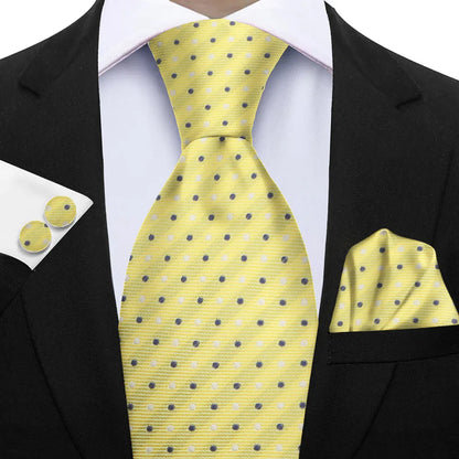 Yellow polka dot tie with matching cufflinks and pocket square on a black suit. Elegant men’s 3-piece tie set: striped necktie, floral pocket square, matching cufflinks. Fashionable polyester accessories for formal occasions.