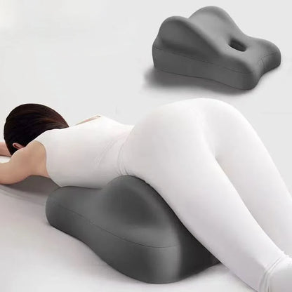 Person using a gray ergonomic pillow on a white background