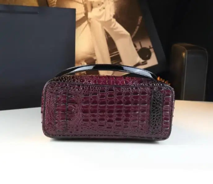 Purple textured handbag on a white surface with a blurred background. Vintage genuine leather bucket tote bag with crocodile print. Soft medium-hardness leather, zipper closure, interior pockets. Stylish crossbody bag UK.