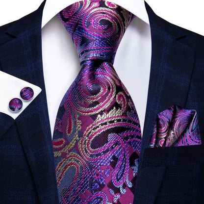 Navy suit with a purple paisley tie, pocket square, and cufflinks on a white background. Men’s luxury paisley silk tie and pocket square set, 8.5cm wide, for business or wedding. Red formal necktie, ftf fashion UK.
