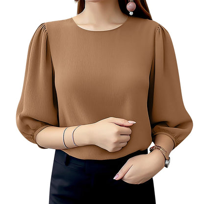 Brown blouse with long sleeves worn by a person on a white background