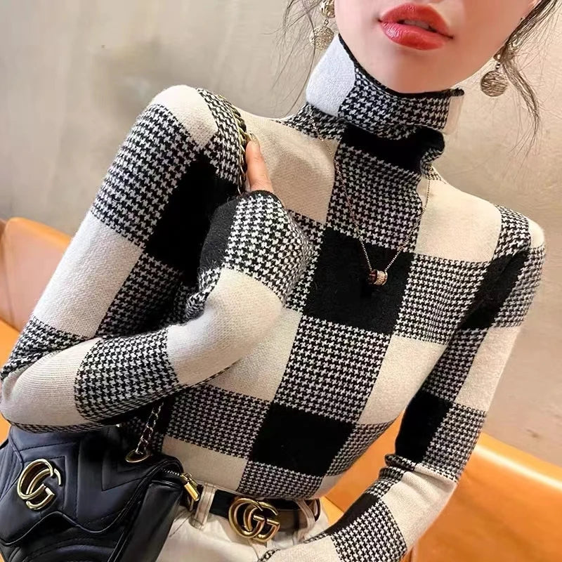Person wearing a black and white checkered sweater with a Gucci handbag.