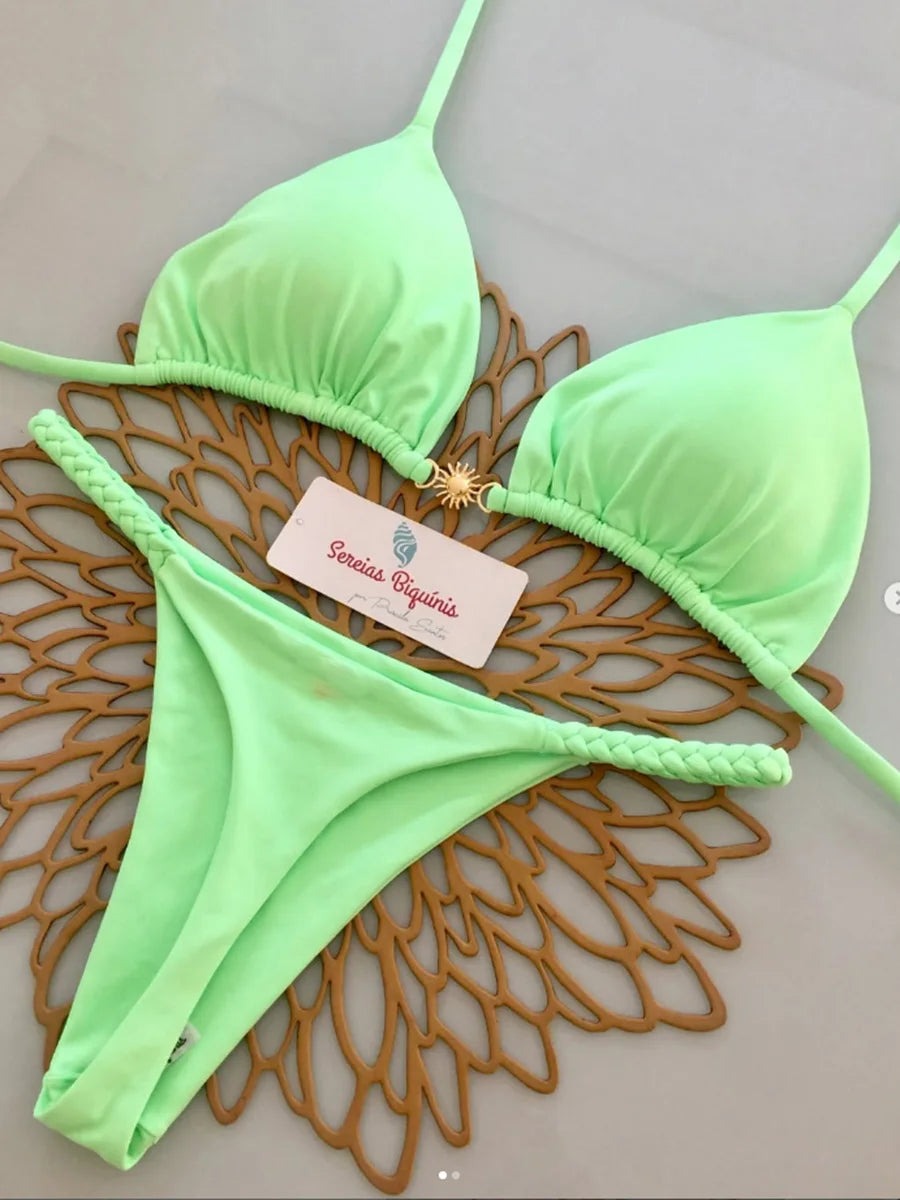 Green bikini set with a brand tag on a textured surface