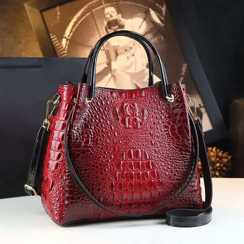 Red textured handbag with black handle and strap on a white surface. Vintage genuine leather bucket tote bag with crocodile print. Soft medium-hardness leather, zipper closure, interior pockets. Stylish crossbody bag UK.