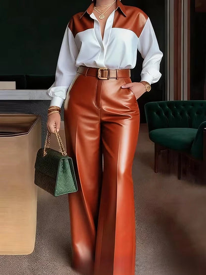 Person wearing a white shirt with brown accents and red pants, holding a green handbag in an indoor setting.