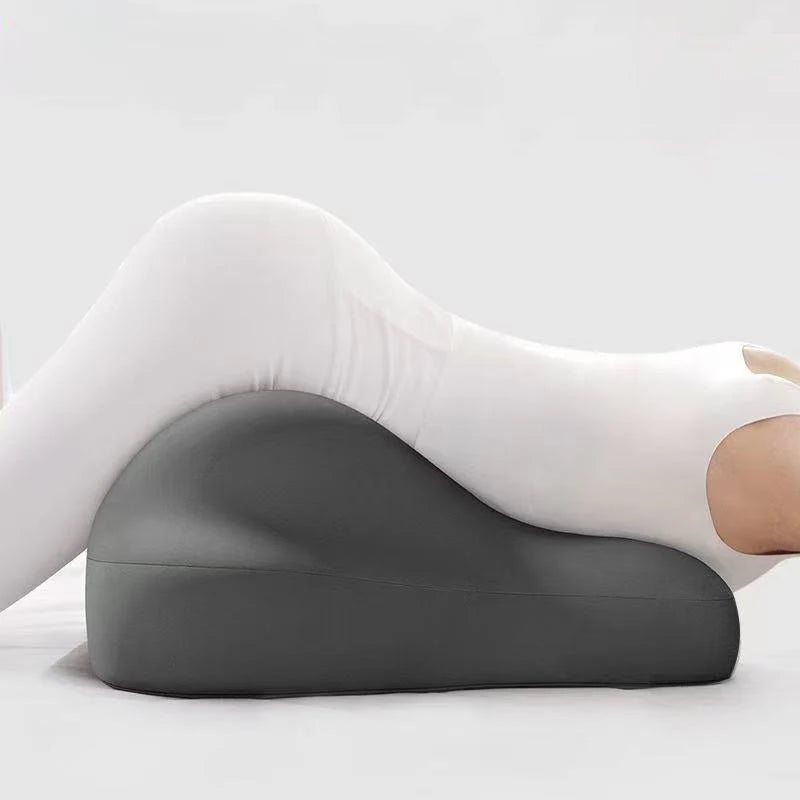 Person using a gray wedge pillow on a white background