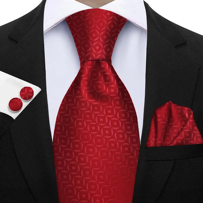 Red patterned tie with matching pocket square and cufflinks on a black suit. Elegant men’s 3-piece tie set: striped necktie, floral pocket square, matching cufflinks. Fashionable polyester accessories for formal occasions.