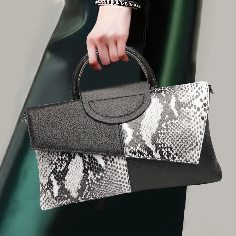 Handbag with black and snake print design held by a person