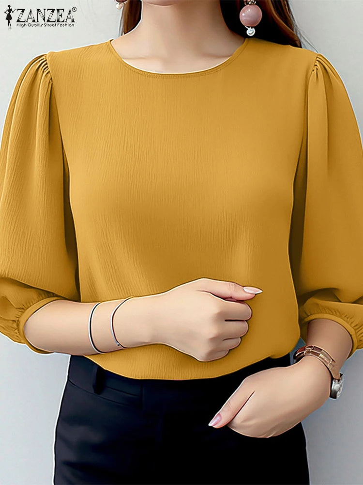 Yellow blouse with puffed sleeves worn by a model on a plain background