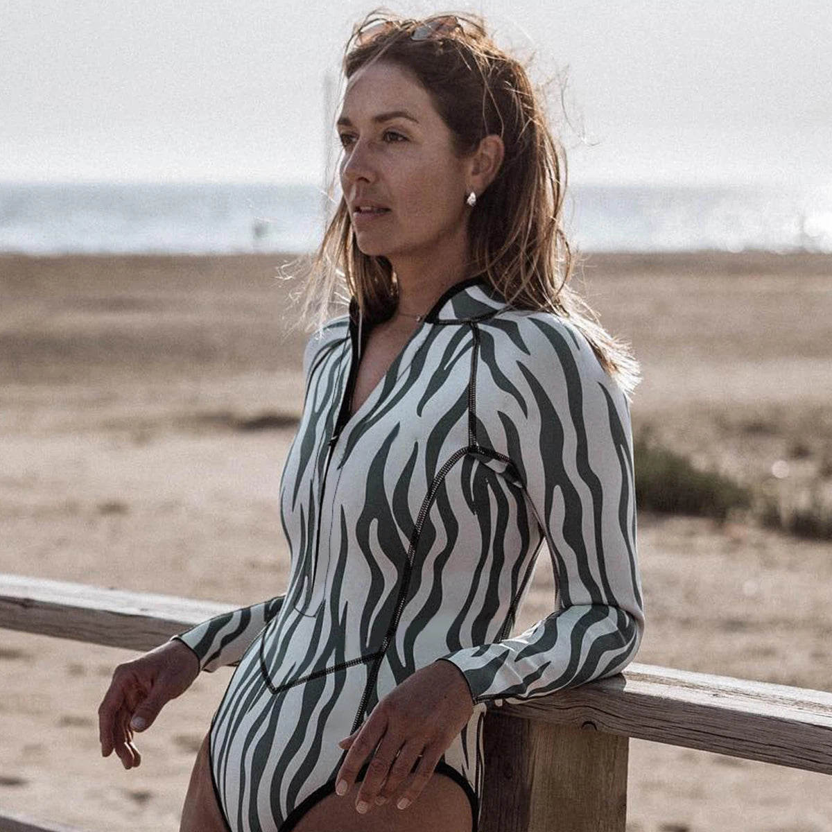 Woman wearing a zebra-striped swimsuit on a beach.