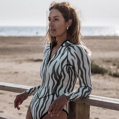 Woman wearing a zebra-striped swimsuit on a beach.