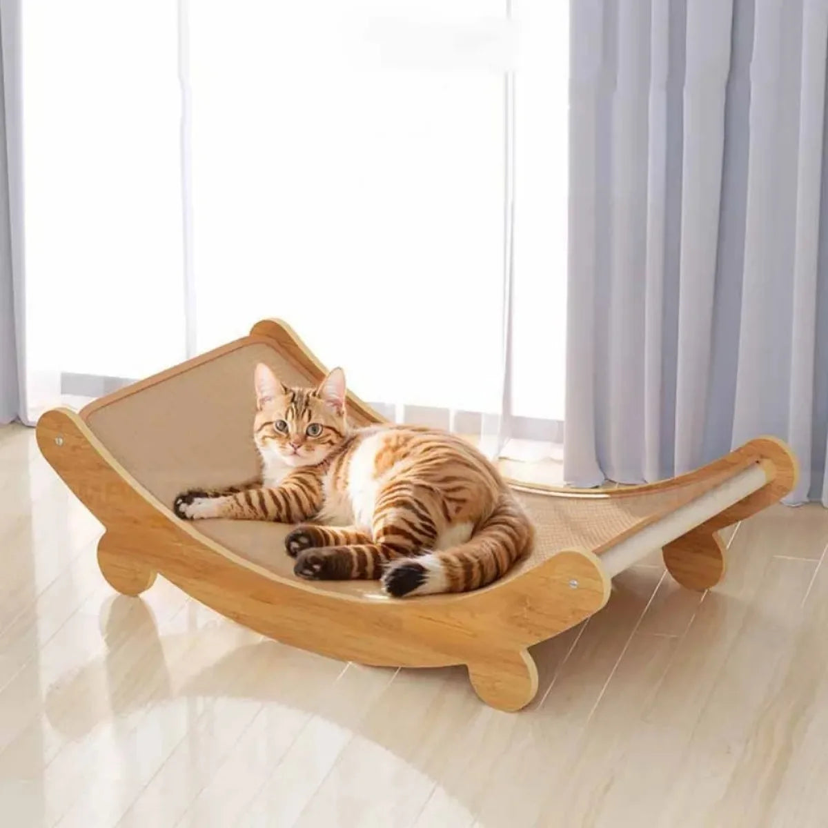 Cat lying on a wooden cat hammock in a bright room with large windows. Wooden cat scratching pad & bed, single layer, sisal surface, pet furniture, kitten recliner, multi-purpose cat toy for lounging and claw care.