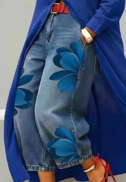 Person wearing a blue floral-patterned coat over a blue denim jacket with floral designs.