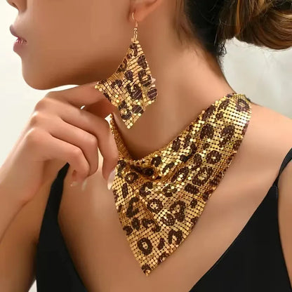 Gold and leopard print necklace and earrings on a model against a neutral background. Women’s fashion jewelry set with leopard print triangle scarf necklace and sparkling drop earrings, perfect for parties and stylish events.