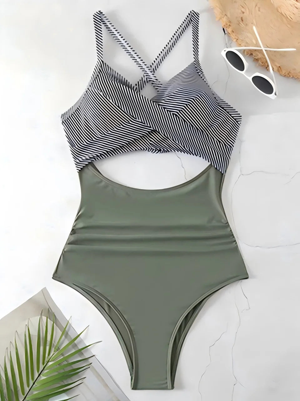 Green one-piece swimsuit with striped top on a white surface
