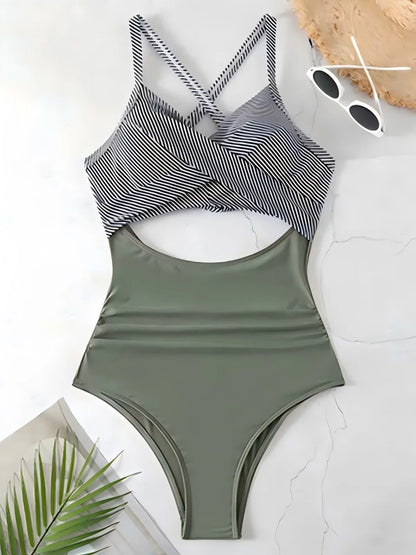 Green one-piece swimsuit with striped top on a white surface