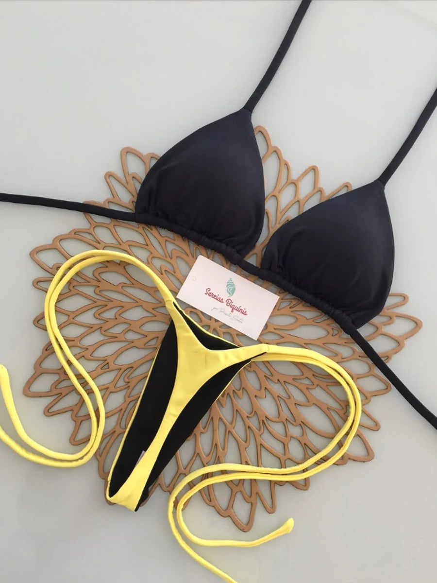 Black and yellow bikini set with a brand tag on a decorative mat