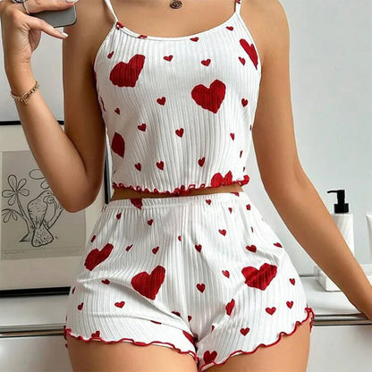 White romper with red heart patterns worn by a person, standing against a neutral background. Soft women’s pajama set, 2 pieces white tank top and shorts, breathable fabric with love print, comfortable casual sleepwear, UK FTF Market.