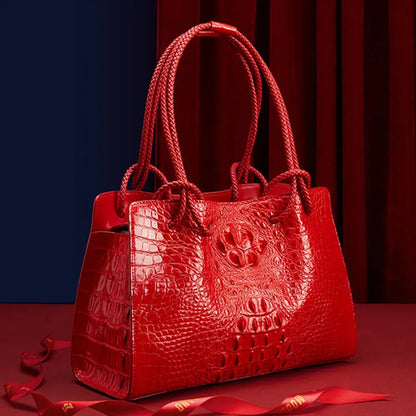 Red textured handbag on a red background. Luxury women’s tote bag in genuine red crocodile leather. Large capacity, stylish handle, fashion travel handbag. Perfect for shoulder or portable use UK.