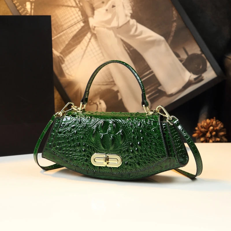 Green handbag with gold accents on a light surface with a blurred background