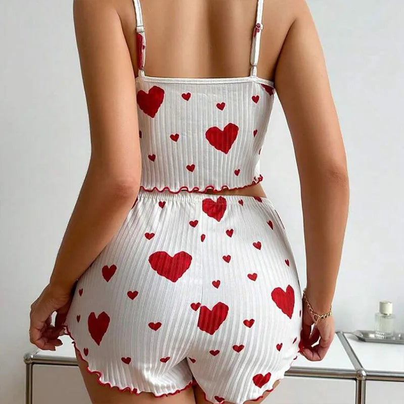 White romper with red heart patterns worn by a person, on a neutral background. Soft women’s pajama set, 2 pieces white tank top and shorts, breathable fabric with love print, comfortable casual sleepwear, UK FTF Market.