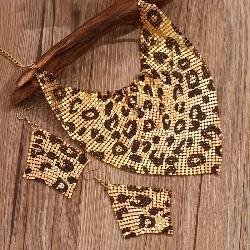 Leopard print mesh necklace and earrings on a wooden surface. Women’s fashion jewelry set with leopard print triangle scarf necklace and sparkling drop earrings, perfect for parties and stylish events.
