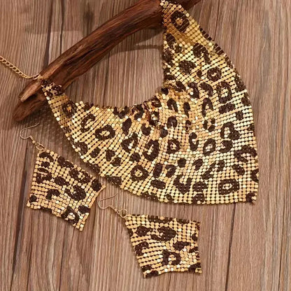 Leopard print mesh necklace and earrings on a wooden surface. Women’s fashion jewelry set with leopard print triangle scarf necklace and sparkling drop earrings, perfect for parties and stylish events.