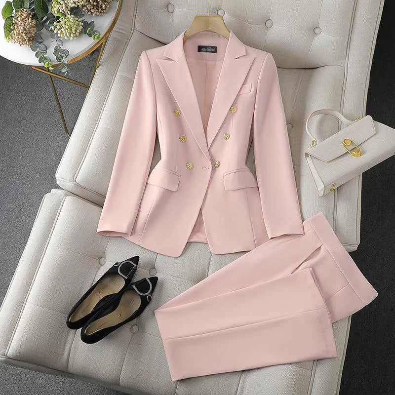Pink suit with matching pants, shoes, and handbag on a gray sofa.