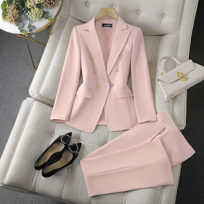 Pink suit with matching pants, shoes, and handbag on a gray sofa.