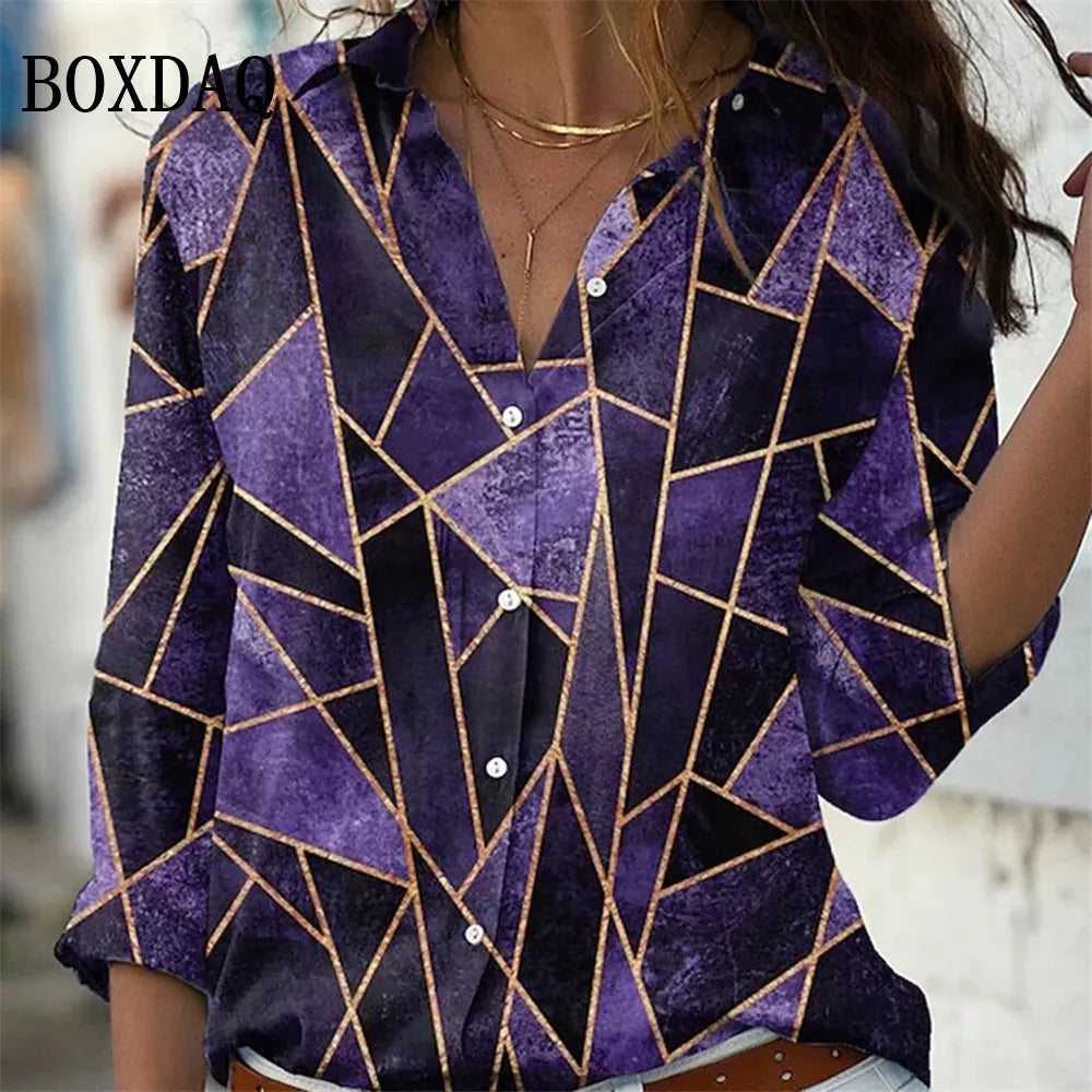 A woman wearing a purple button-up shirt with a geometric gold line pattern, featuring textured purple panels and gold lines. The brand name BOXDAQ is visible in the top left corner.