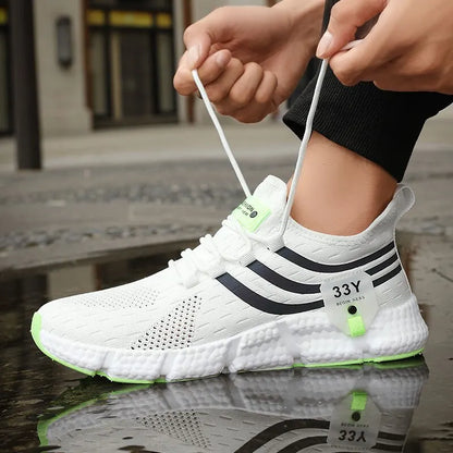 White athletic shoe with black stripes and green accents being worn on a reflective surface.