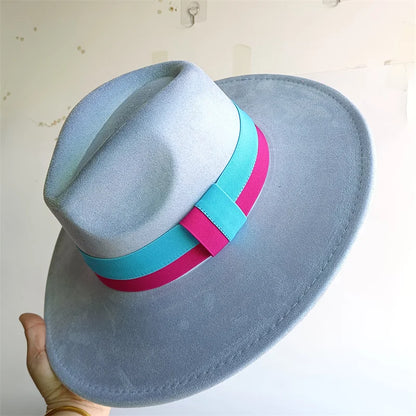 Blue fedora hat with pink and turquoise bands held against a light background