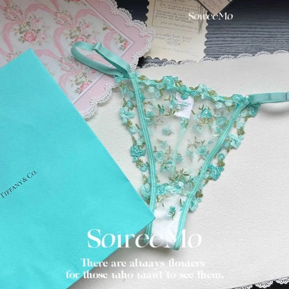 Teal lace lingerie set on a floral-patterned surface with Tiffany & Co. box.
