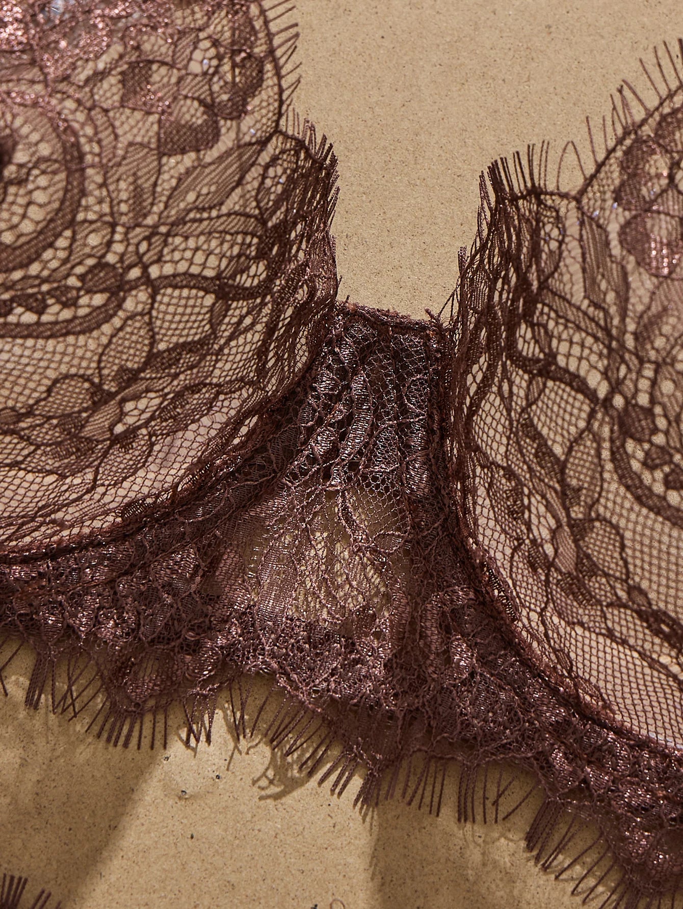 Close-up of intricate lace fabric with a textured background