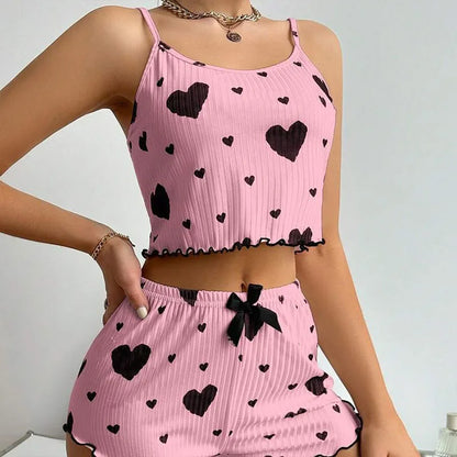 Pink outfit with black heart patterns on a plain background. Soft women’s pajama set, 2 pieces white tank top and shorts, breathable fabric with love print, comfortable casual sleepwear, UK FTF Market.