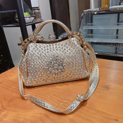 Decorative handbag with rhinestone embellishments on a wooden surface. Large genuine leather dumpling bag with diamond rhinestone clip and lock clasp. Soft handle, multiple compartments. Fashionable shoulder tote for women.