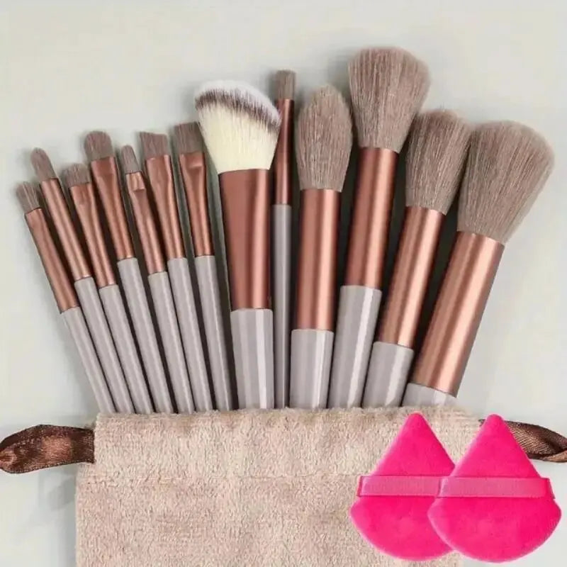 Set of makeup brushes with a carrying case and pink applicators on a light background. Soft fluffy makeup brush set with wool fiber bristles and plastic handles. Complete set for powder, foundation, eyeshadow, and beauty blending.