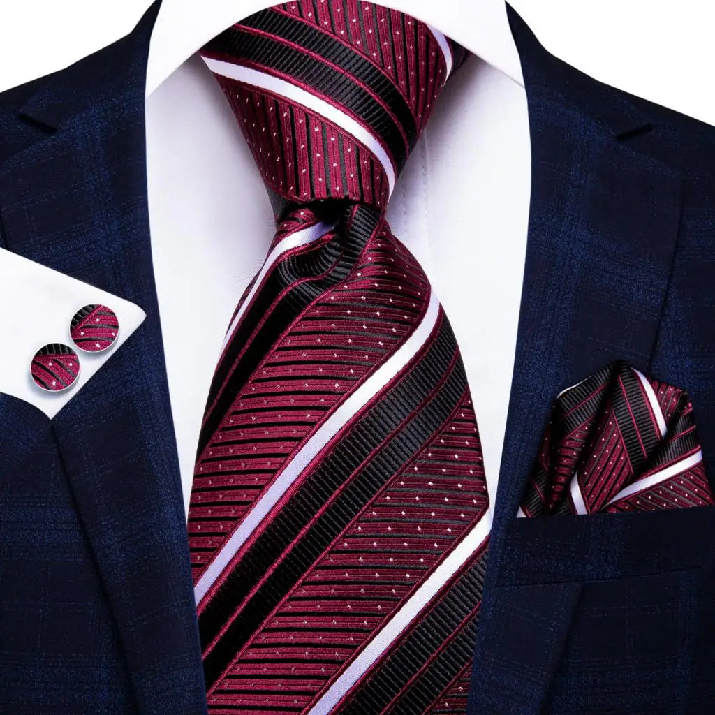 Maroon striped tie with matching pocket square and cufflinks on a navy suit jacket. Men’s luxury paisley silk tie and pocket square set, 8.5cm wide, for business or wedding. Red formal necktie, ftf fashion UK.