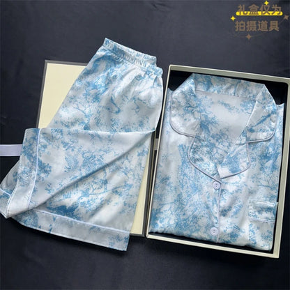 Floral pajama set with shirt and pants in a box on a dark background. Women’s cherries print summer pajamas set—faux satin V-neck top and shorts, funny cute style. Lightweight, comfortable, UK fashion set.