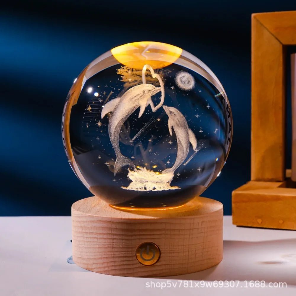 Glass ball with dolphins on a wooden base against a dark blue background. 3D laser engraved axolotl crystal ball lamp with USB LED base, vibrant colours UK.
