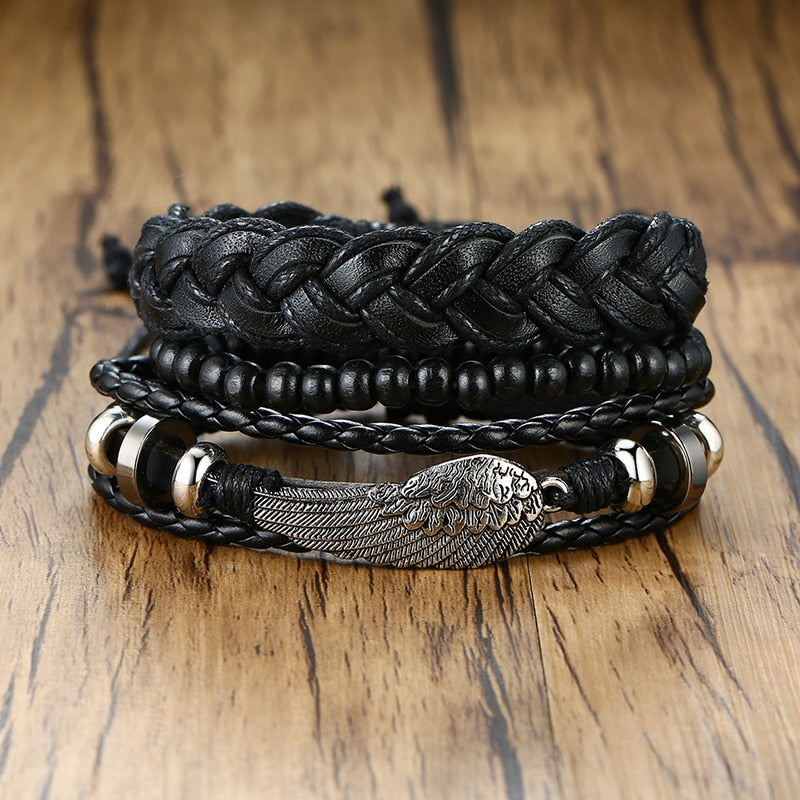A set of bohemian style leather wrap bracelets with various charms, including a tree of life charm, in black and brown colors.