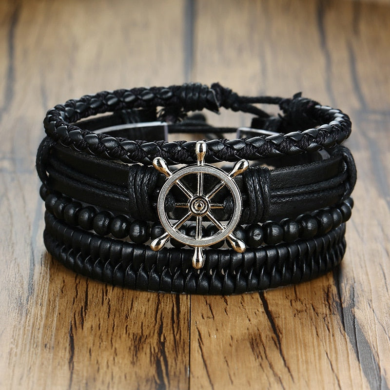 A set of bohemian style leather wrap bracelets with various charms, including a tree of life charm, in black and brown colors.